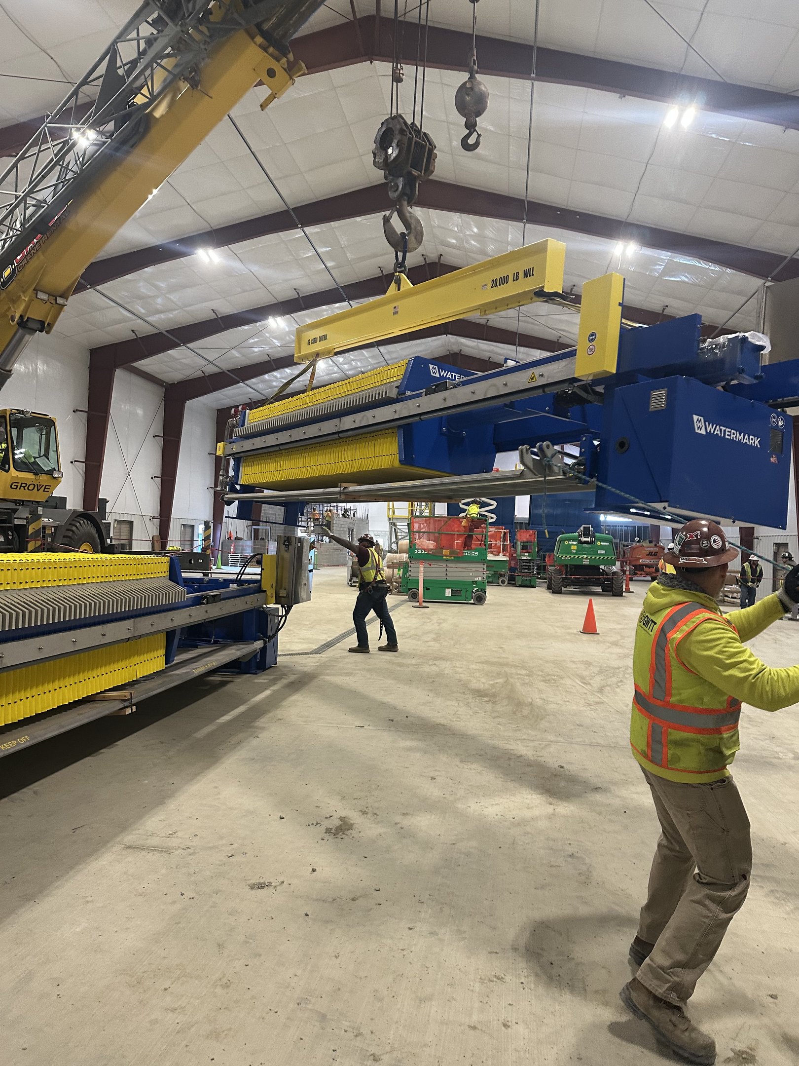 Crew under a suspended load inside a water treatment plant.